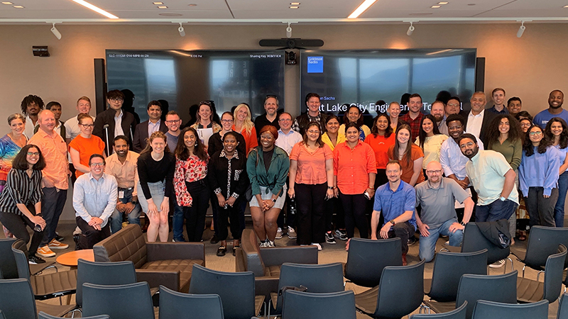 A group of colleaagues poses for a photo in a seminar room