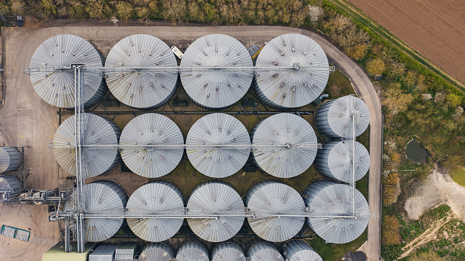 An aerial image of grain silos next to a field.